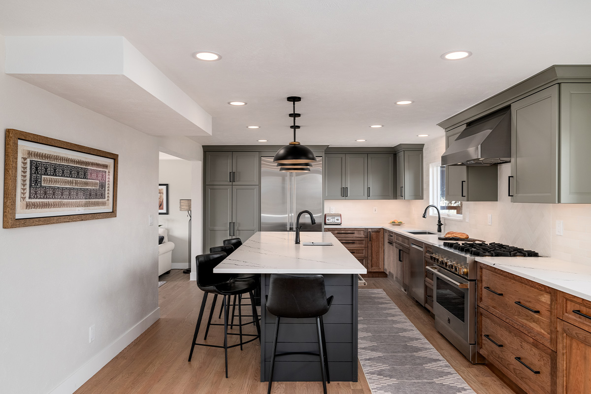 Painted gray and stained brown kitchen cabinets.