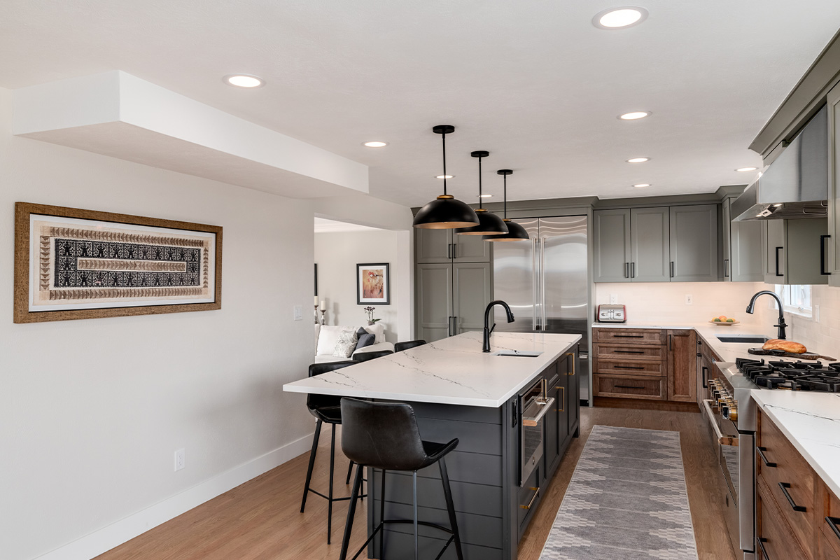 Painted gray and stained brown kitchen cabinets.