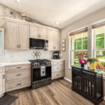 Light stained kitchen cabinets with black appliances.