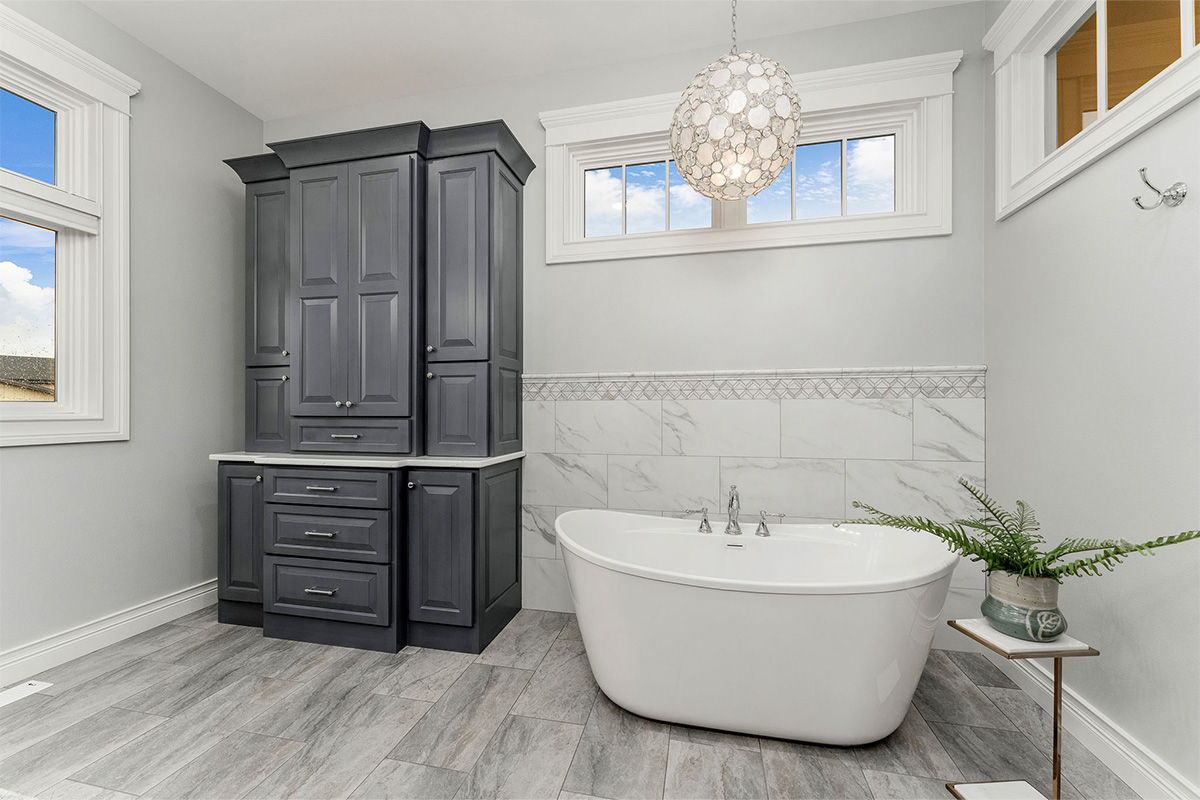 Painted bathroom cabinet with white stand-alone tub.