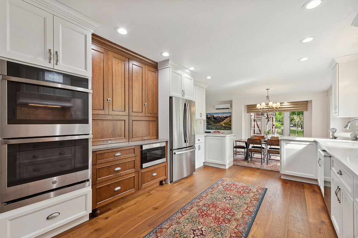 White kitchen with brown stained accent cabinets
