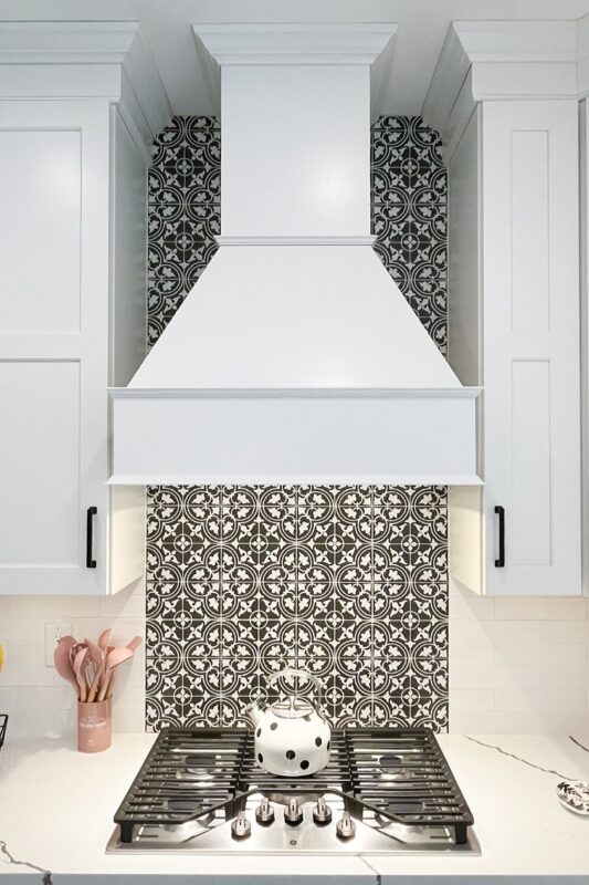 Painted white wood range hood with decorative backsplash