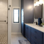 Bathroom with walk-in shower and vanity cabinets painted in Hale Navy color.