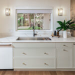 Oyster painted kitchen cabinets with sink and window looking outside