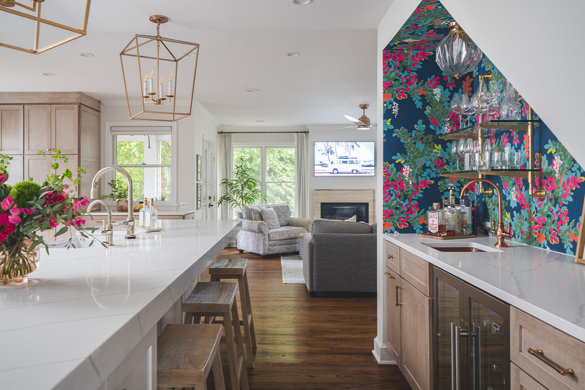 White kitchen and island with floral wallpaper in a nook