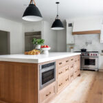 White painted perimeter and light brown stained island cabinets.