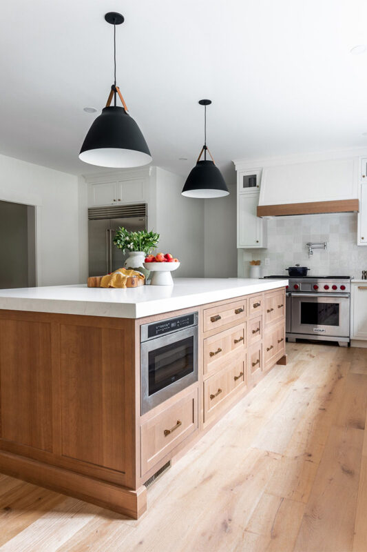 White painted perimeter and light brown stained island cabinets.