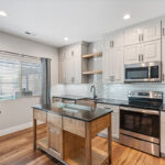 Painted Gun Smoke kitchen perimeter cabinets with a brown stained island cabinet.