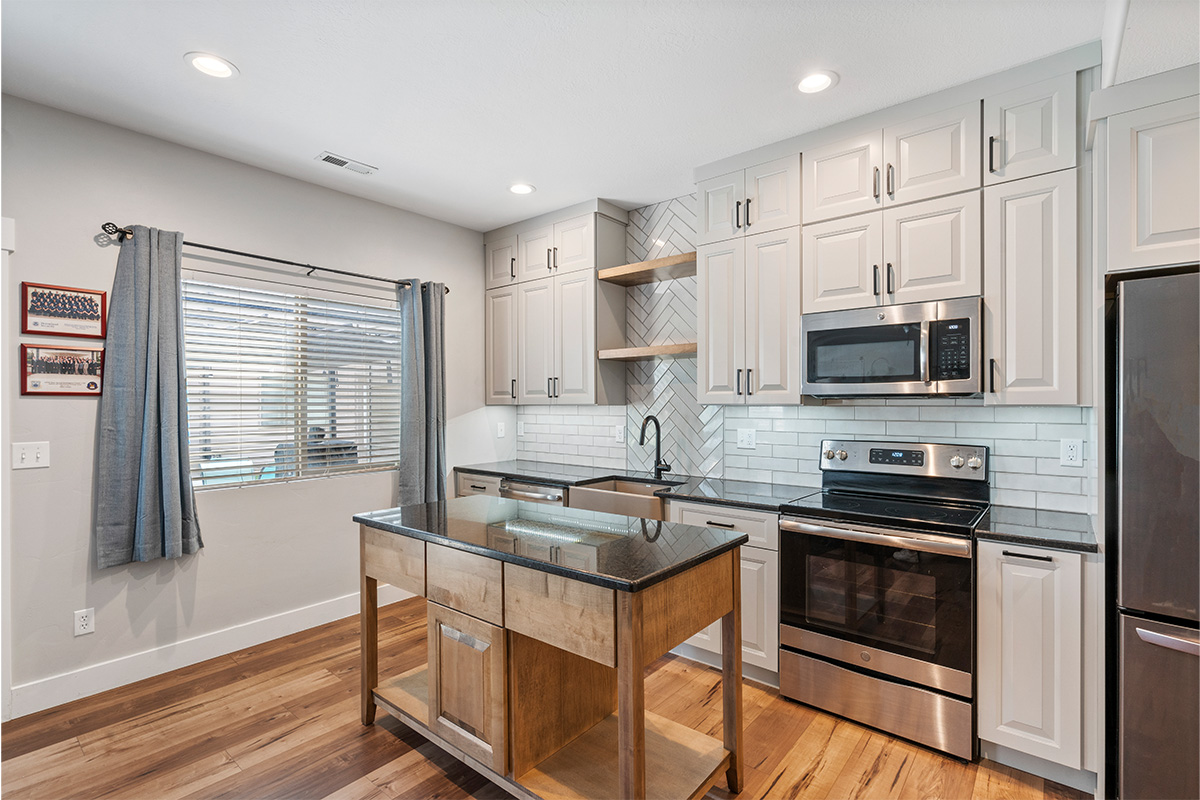 Painted Gun Smoke kitchen perimeter cabinets with a brown stained island cabinet.
