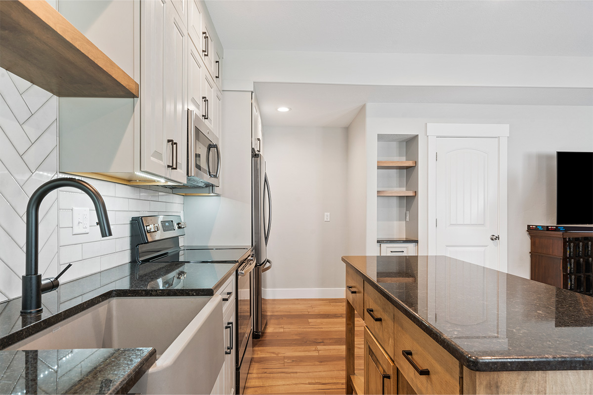 Painted Gun Smoke kitchen perimeter cabinets with a brown stained island cabinet.