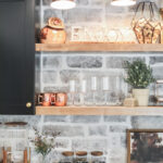 Black bar cabinets with stained floating shelves