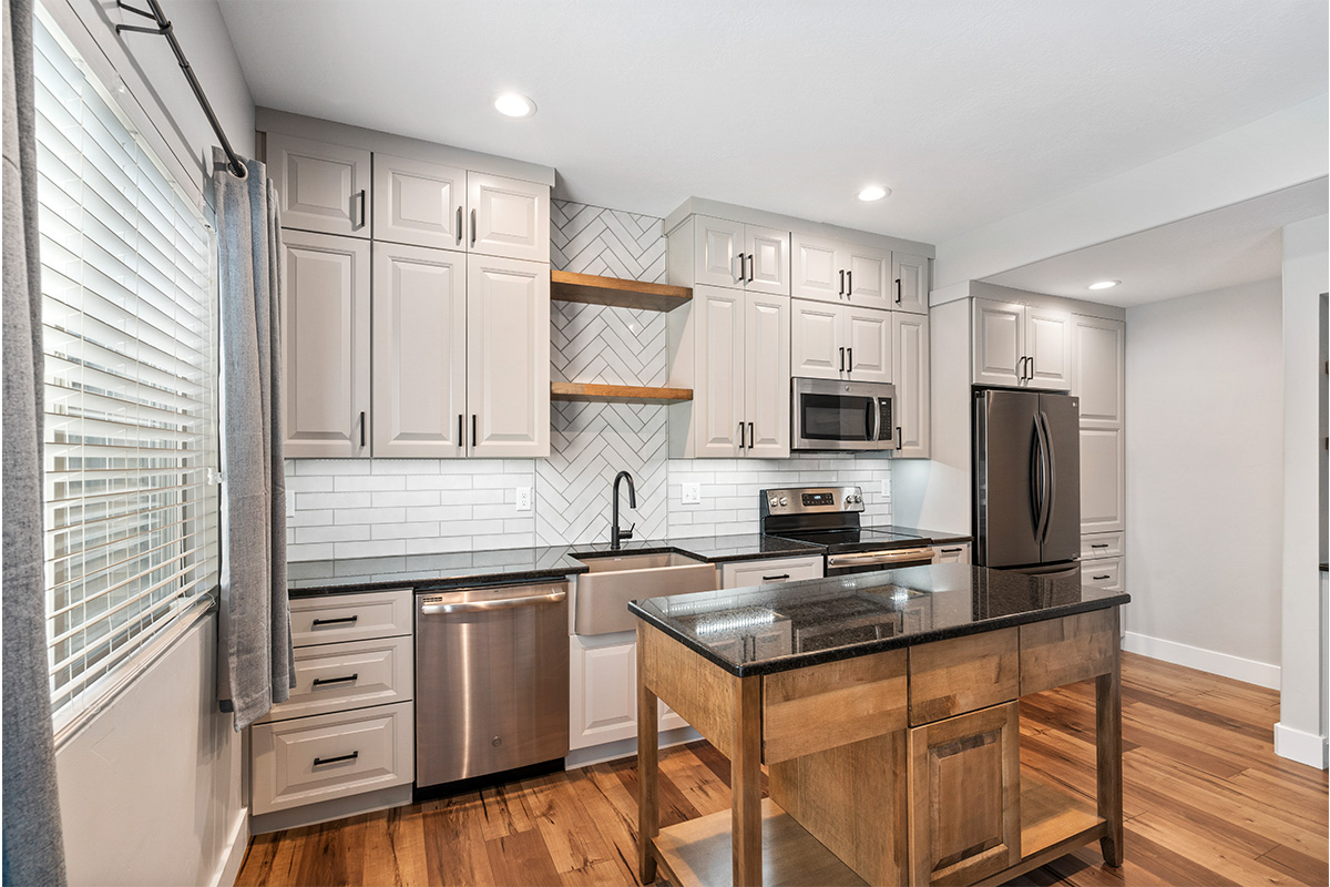 Painted Gun Smoke kitchen perimeter cabinets with a brown stained island cabinet.