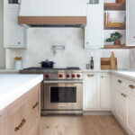 White painted perimeter and light brown stained island cabinets.