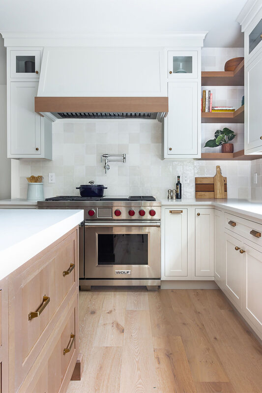 White painted perimeter and light brown stained island cabinets.
