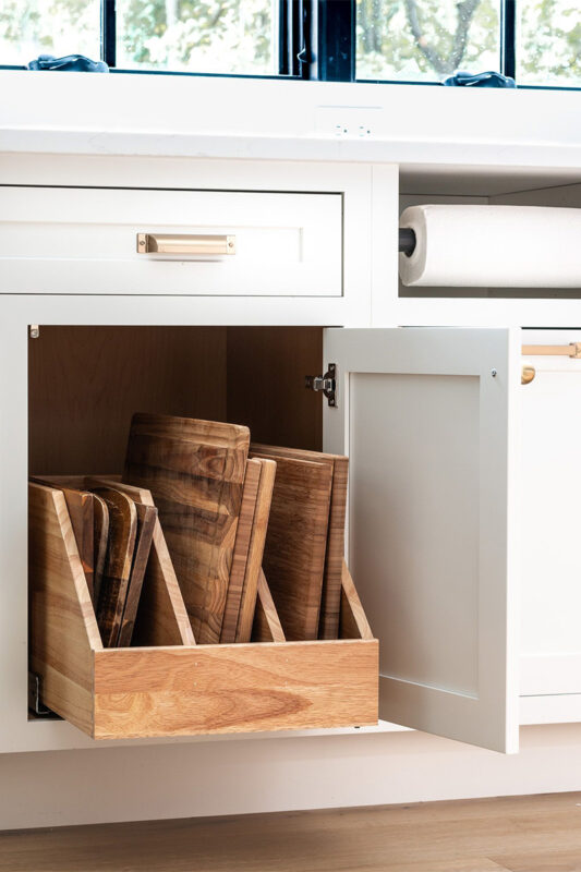 White painted kitchen cabinet with tray divider pullout drawer shown.