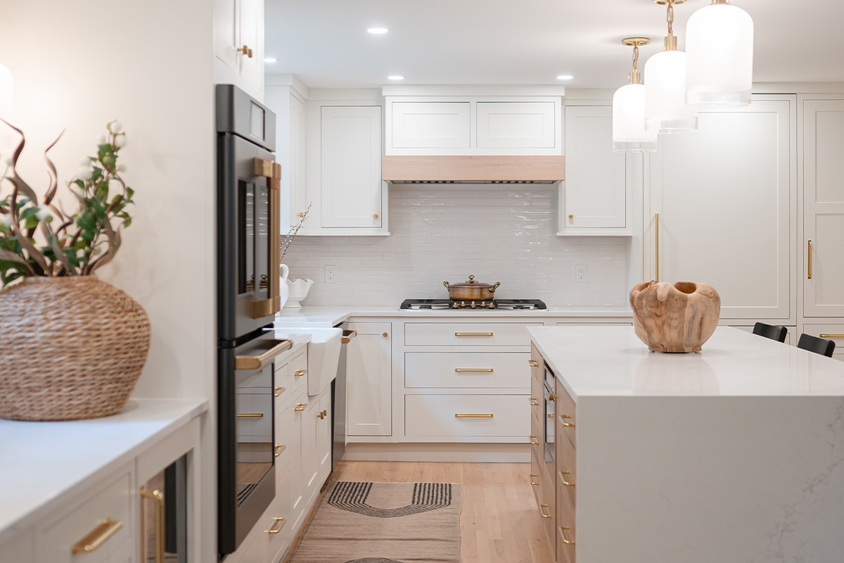 Kitchen with White perimeter cabinets and Quartersawn White Oak island cabinets stained in light brown Pampas finish.