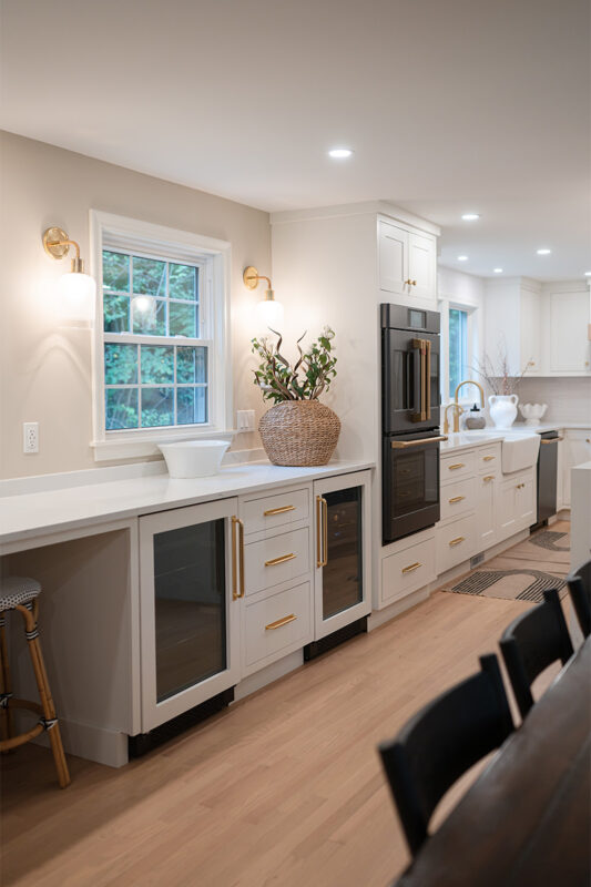 Kitchen with White perimeter cabinets and Quartersawn White Oak island cabinets stained in light brown Pampas finish.