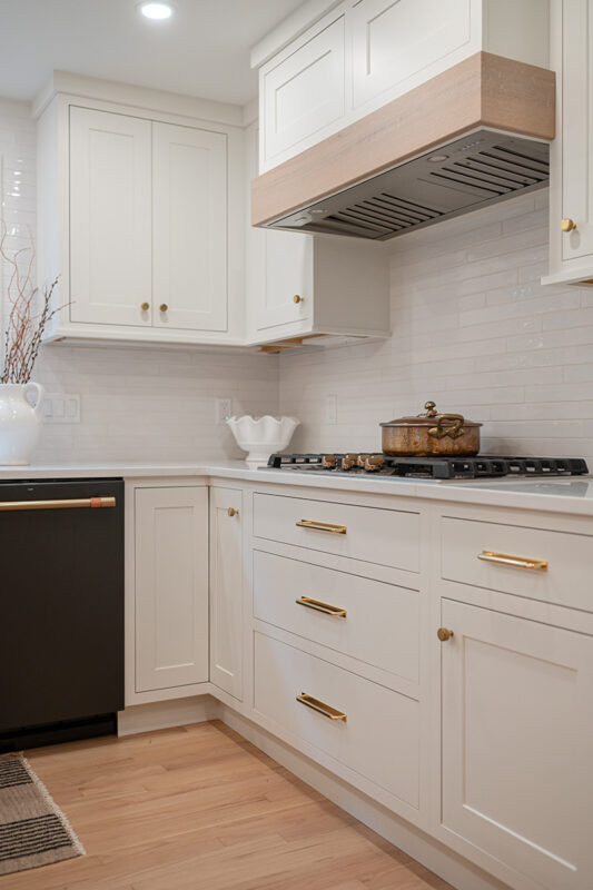 Kitchen with White perimeter cabinets and Quartersawn White Oak island cabinets stained in light brown Pampas finish.