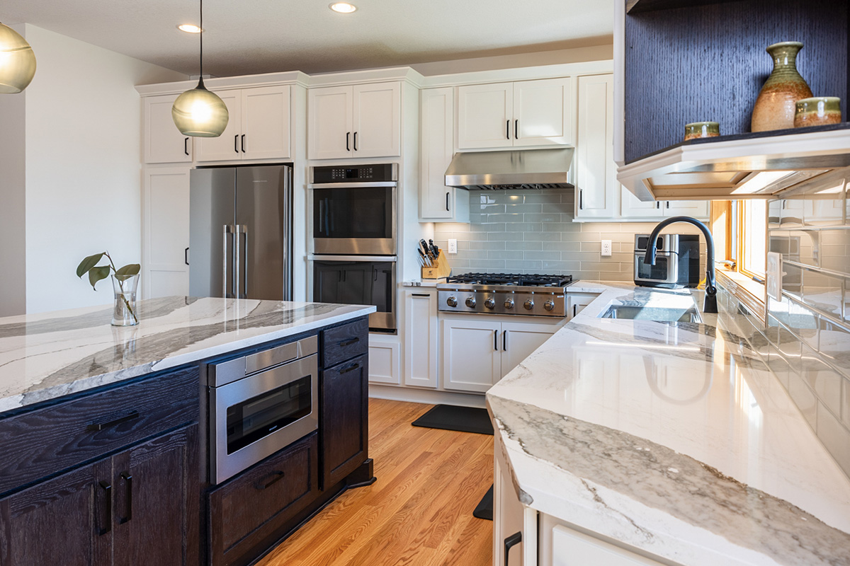 White kitchen with dark stained island and accents.