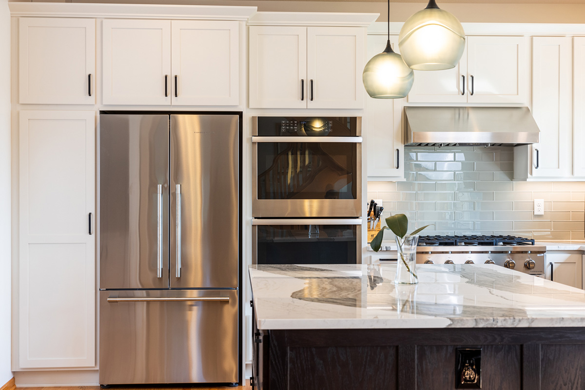 White kitchen with dark stained island and accents.