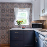 White and blue kitchen cabinets. View out a window.