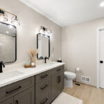 Gray bathroom vanity with 2 sinks and mirrors