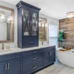Blue bathroom vanity with standalone tub