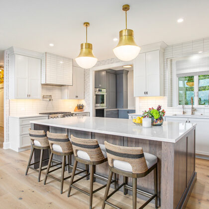 White kitchen cabinets with stained hickory island.