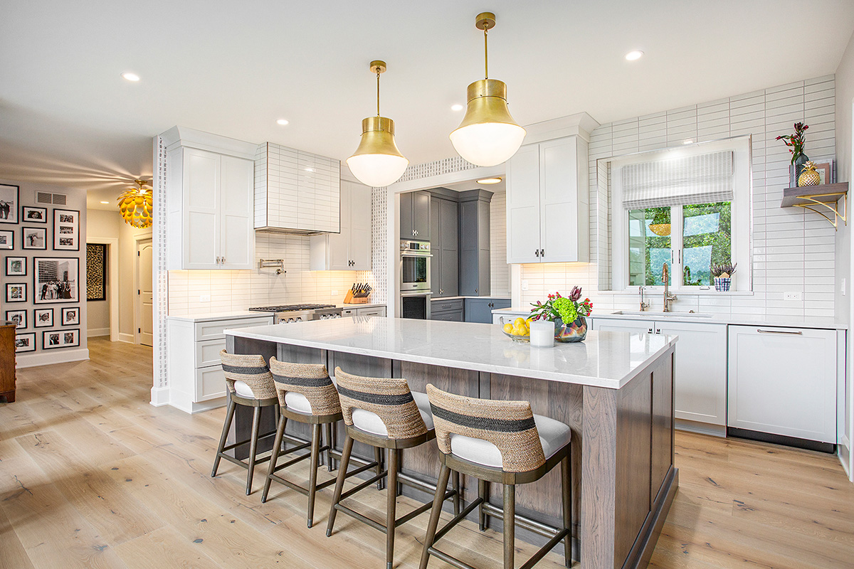 White kitchen cabinets with stained hickory island.