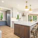 White kitchen cabinets with stained hickory island.