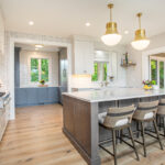 White kitchen cabinets with stained hickory island.