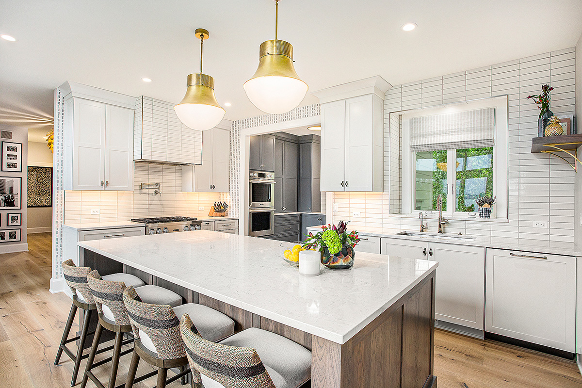 White kitchen cabinets with stained hickory island.