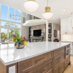 White kitchen cabinets with stained hickory island.