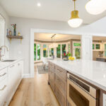 White kitchen cabinets with stained hickory island.
