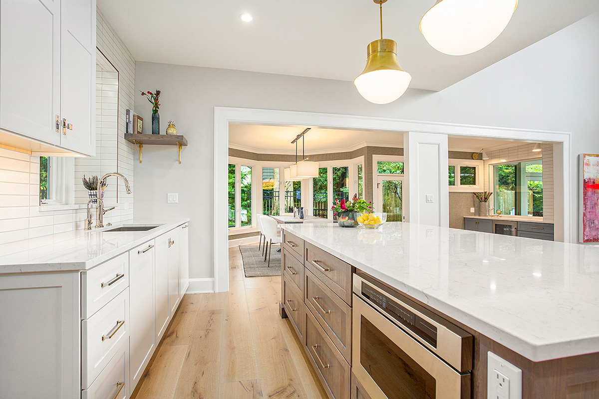 White kitchen cabinets with stained hickory island.