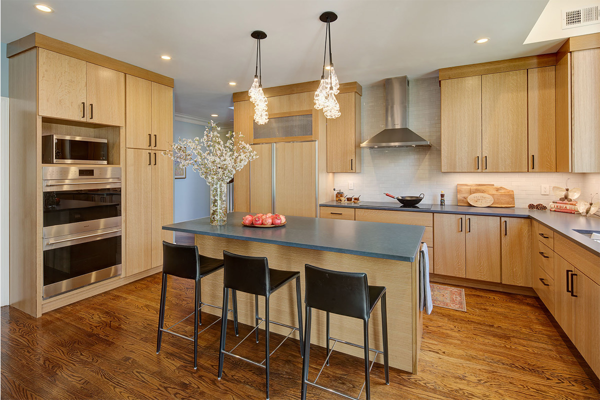 Light brown stained kitchen with island seating.