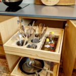 Base cabinet with roll trays pulled out showing utensils, etc.