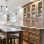 White and Cashew stained kitchen cabinets with long island with seating