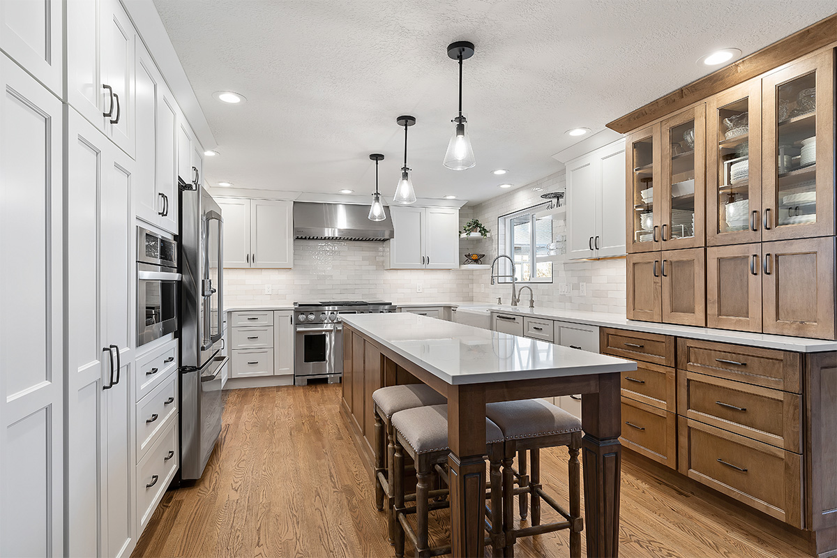 White and Cashew stained kitchen cabinets with long island with seating