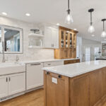 White and Cashew stained kitchen cabinets with long island with seating