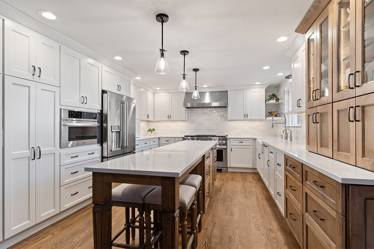 White and Cashew stained kitchen cabinets with long island with seating