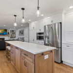 White and Cashew stained kitchen cabinets with long island with seating
