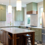 Painted kitchen perimeter cabinerts with walnut island.