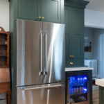 Purple painted kitchen cabinets with stainless steel fridge and beverage cooler.