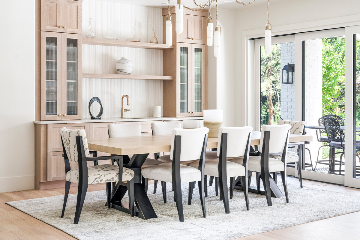 Light stained dining room serving station with table and chairs.