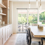 Light stained dining room serving station with table and chairs.