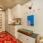 Light brown painted mudroom cabinets with bench seating.