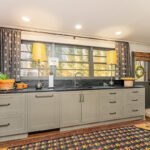 Brown painted kitchen with island and wood beams.