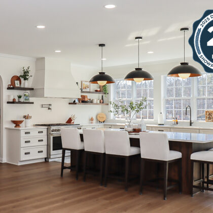 White perimeter kitchen cabinets with a dark stained island.