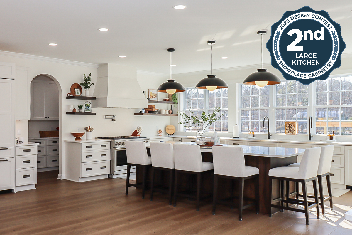 White perimeter kitchen cabinets with a dark stained island.